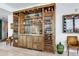 Stylish in-home bar featuring custom cabinetry, glass shelving, and a wine refrigerator at 2912 W Santiago St # 1504, Tampa, FL 33629