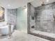 Modern bathroom with a soaking tub, glass-enclosed shower, and sleek gray tile, offering a serene experience at 2912 W Santiago St # 1504, Tampa, FL 33629