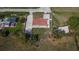 Aerial view of home featuring a red roof, spacious driveway, fenced yard, and covered parking area at 3012 Bonita Dr, Plant City, FL 33566