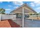 View of carport and fenced yard featuring mulch and fresh landscaping at 3012 Bonita Dr, Plant City, FL 33566