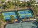 Community tennis courts with shaded seating areas, surrounded by lush greenery and trees at 3106 Francoa Dr, Odessa, FL 33556
