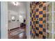 Colorful tiled shower with glass block wall, next to dressing room with dresser and mirror at 3116 W Wallcraft, Tampa, FL 33611