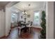Bright dining room with a modern chandelier, large windows with curtains, and hardwood floors at 3116 W Wallcraft, Tampa, FL 33611