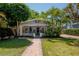 Charming bungalow featuring a brick walkway, manicured lawn, and lush tropical landscaping at 3116 W Wallcraft, Tampa, FL 33611