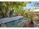 Large backyard hot tub covered with a white towel, surrounded by lush greenery at 3116 W Wallcraft, Tampa, FL 33611
