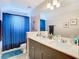 Bathroom featuring a double sink vanity with modern fixtures, neutral paint and privacy curtain at 3503 Albritton St, New Port Richey, FL 34655