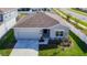 Aerial view showcases the home's facade, landscaping, and well-kept lawn at 35524 Quartz Lake Dr, Zephyrhills, FL 33541
