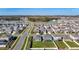 An aerial view showcases a community of homes with lake views, green landscaping and a view of the woods at 35524 Quartz Lake Dr, Zephyrhills, FL 33541
