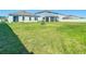 Spacious backyard featuring lush grass and secure white fencing at 35524 Quartz Lake Dr, Zephyrhills, FL 33541