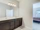Bathroom showcasing a double vanity with dark wood cabinets and a large mirror at 35524 Quartz Lake Dr, Zephyrhills, FL 33541