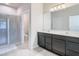 Bathroom features a double vanity, shower with glass door, and toilet in a separate room at 35524 Quartz Lake Dr, Zephyrhills, FL 33541