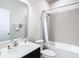 Modern bathroom featuring a combined bathtub and shower with stylish gray tiling, complemented by a white vanity and toilet at 35524 Quartz Lake Dr, Zephyrhills, FL 33541