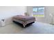 Minimalist bedroom with large window and a bed topped with a patterned blanket at 35524 Quartz Lake Dr, Zephyrhills, FL 33541