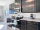 Kitchen showcasing dark cabinetry, stainless steel appliances, and granite countertops near a bright window at 35524 Quartz Lake Dr, Zephyrhills, FL 33541