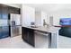 Open kitchen with a stainless steel dishwasher, sink, and large island with granite countertops at 35524 Quartz Lake Dr, Zephyrhills, FL 33541