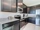 Close-up of the kitchen featuring stainless steel appliances and dark cabinets with granite countertops at 35524 Quartz Lake Dr, Zephyrhills, FL 33541