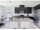 Modern kitchen features dark cabinetry, stainless steel appliances, and a large island with granite countertops at 35524 Quartz Lake Dr, Zephyrhills, FL 33541
