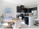 Modern kitchen with dark cabinetry, stainless steel appliances, and a center island near the dining area at 35524 Quartz Lake Dr, Zephyrhills, FL 33541