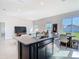 Kitchen island featuring a sink and granite countertops, flowing into the living and dining areas at 35524 Quartz Lake Dr, Zephyrhills, FL 33541