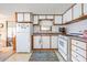 Efficient kitchen space with wood-trimmed cabinets and essential appliances at 37042 Lois Ave, Zephyrhills, FL 33542