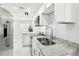 Open kitchen features granite counters, white cabinets and stainless appliances at 4208 E Sandalwood S Cir, Tampa, FL 33617