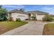 Well-maintained single-story home with stucco exterior, an attached garage, and a concrete driveway at 4611 Anaconda Dr, New Port Richey, FL 34655