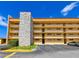 A tan condo building with parking, stone exterior design, and multiple floors of balconies at 5820 N Church Ave # 430, Tampa, FL 33614