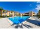 Bright community pool and deck area, with clear blue water and lounge seating; palm trees and blue sky at 5820 N Church Ave # 430, Tampa, FL 33614