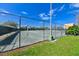 Fenced tennis court with manicured grass; partially cloudy blue sky at 5820 N Church Ave # 430, Tampa, FL 33614