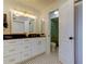 Bathroom features white cabinets with gold hardware, black speckled granite counters, and a modern tile shower at 6290 Bahia Del Mar Cir # 5, St Petersburg, FL 33715
