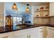 Well-appointed kitchen with modern lighting, granite countertops, white cabinets and stainless faucet at 6290 Bahia Del Mar Cir # 5, St Petersburg, FL 33715