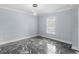 Bedroom showcases modern lighting, neutral walls, window, and dark marble floors at 6489 Hazelwood Rd, Spring Hill, FL 34608