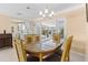 Bright dining room with a glass table, view to kitchen, and sliding door to the screened lanai at 6891 4Th S St, St Petersburg, FL 33713