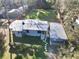 Aerial view showing metal roof, lush yard, and detached garage with covered parking at 7043 Lang St, Brooksville, FL 34601