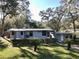 Inviting exterior with lush lawn, mature landscaping, and charming home design at 7043 Lang St, Brooksville, FL 34601