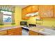 Well-lit kitchen featuring wood cabinets, gas range, and functional layout at 7043 Lang St, Brooksville, FL 34601
