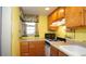 Efficient kitchen featuring wood cabinetry, gas range, and neutral countertops at 7043 Lang St, Brooksville, FL 34601