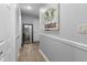 Bright hallway with light gray walls, white trim, and wood-look flooring at 7210 N Manhattan # 1822, Tampa, FL 33614