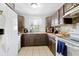 Cozy kitchen featuring brown cabinets, tile backsplash, and white appliances at 7210 N Manhattan # 1822, Tampa, FL 33614