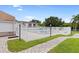 Community pool surrounded by a white fence, pavers, grass and some building at 7210 N Manhattan # 1822, Tampa, FL 33614