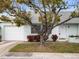 Charming single-story home with a white garage door and a beautifully landscaped front yard at 8460 Calais N # 8406, Pinellas Park, FL 33781
