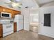 Well-lit kitchen featuring tiled floors, wooden cabinets, white appliances, and seamless access to the adjacent living areas at 8460 Calais N # 8406, Pinellas Park, FL 33781