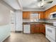 Functional kitchen featuring tiled floors, oak cabinets, white appliances, and plenty of natural light from the window at 8460 Calais N # 8406, Pinellas Park, FL 33781