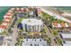 Aerial of condo building surrounded by parking lots, lush landscaping, and more residential buildings at 855 Bayway Blvd # 105, Clearwater, FL 33767