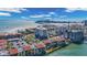Beautiful waterfront condos with red tile roofs next to the beach and bridge on a sunny day at 855 Bayway Blvd # 105, Clearwater, FL 33767
