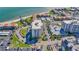 Aerial view of condo complex with parking, landscaping, waterfront views and community pool at 855 Bayway Blvd # 105, Clearwater, FL 33767