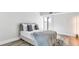 Bright bedroom with a balcony, light colored walls and wood-look floors at 855 Bayway Blvd # 105, Clearwater, FL 33767