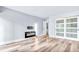 Bright bedroom featuring light wood floors, a wall-mounted TV bracket, and sliding closet doors at 855 Bayway Blvd # 105, Clearwater, FL 33767