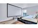Bedroom featuring a large screen, light floors, a modern platform bed, and a private balcony at 855 Bayway Blvd # 105, Clearwater, FL 33767