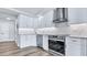 Bright kitchen with white cabinets, stainless steel appliances, and elegant countertops and backsplash at 855 Bayway Blvd # 105, Clearwater, FL 33767